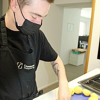 The Compass Software employees are cooking together during their lunch break