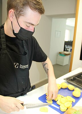 The Compass Software employees are cooking together during their lunch break