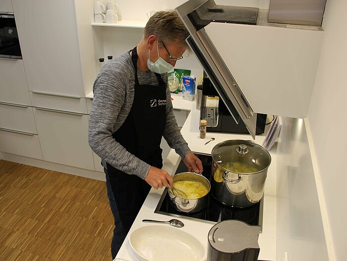 The Compass Software employees are cooking together during their lunch break