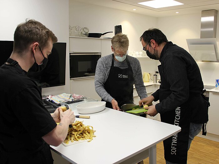 The Compass Software employees are cooking together during their lunch break